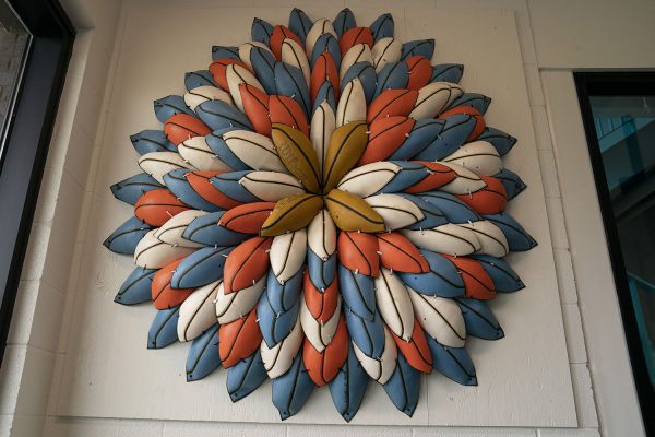 Image of wall sculpture made from deflated basketballs in the shape of a flower.